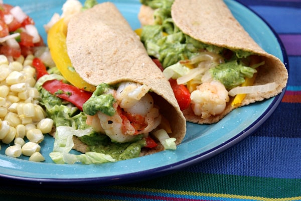 Shrimp Tacos with Avocado Chimichurri Sauce on a blue plate