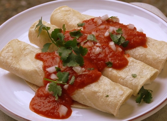 Light bean and cheese enchiladas on a white plate