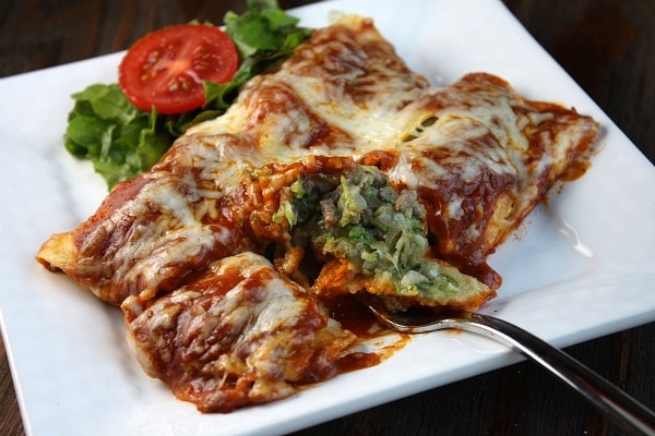 Zucchini Beef Enchiladas on a white plate with a fork