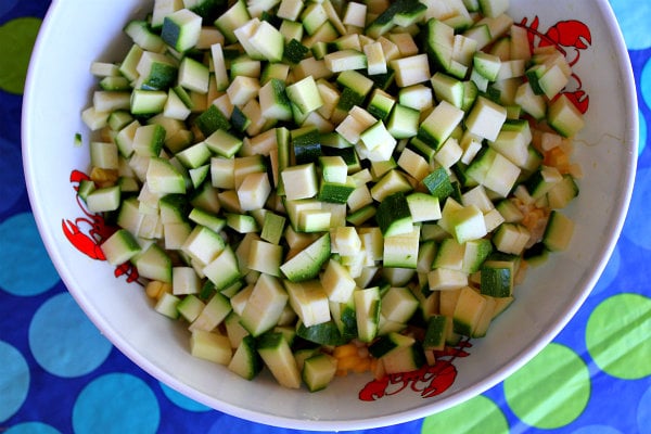 zucchini in a white bowl set on a blue and green polka dot tablecloth