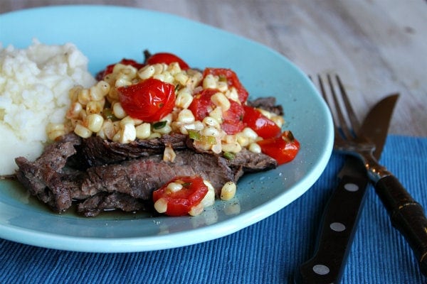 Grilled Skirt Steak with Corn and Cherry Tomato Salad Grilled Skirt Steak with Corn and Cherry Tomato Salad serving on plate