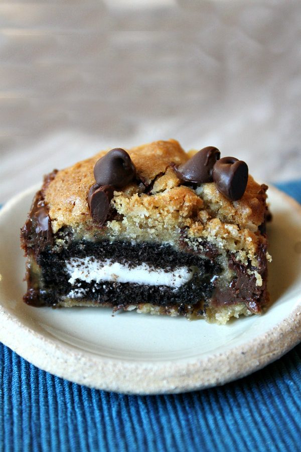 Oreo and Caramel Stuffed Chocolate Chip Cookie Bar on a white plate set on a blue placemat