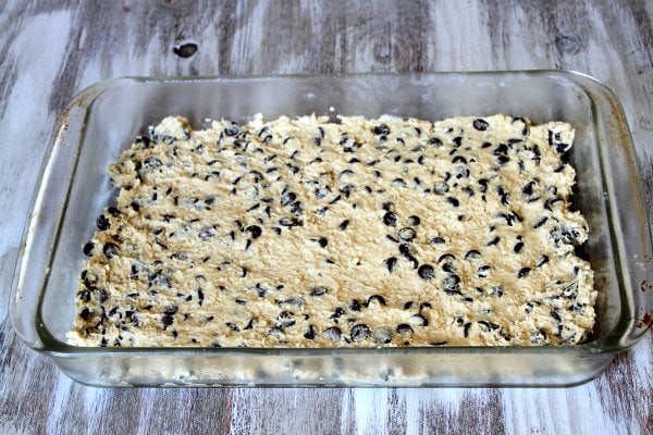 How to Make Oreo and Caramel Stuffed Chocolate Chip Cookie Bars with a layer of cookie dough spread into the bottom of pyrex pan