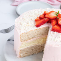 strawberry cheesecake cake with big slice taken out of it