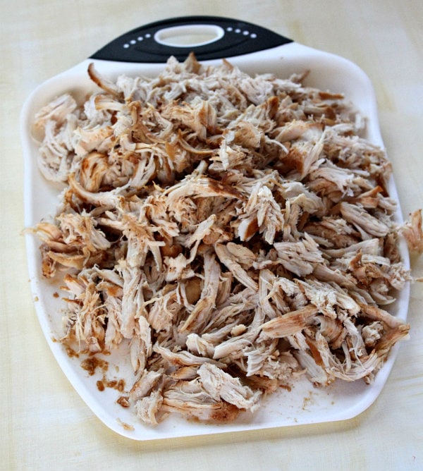 Slow Cooker Pulled Barbecued Chicken Sandwiches recipe from RecipeGirl.com #slow #cooker #slowcooker #crockpot #pulled #bbq #barbecue #barbecued #chicken #sandwiches #recipe #RecipeGirl Pulled Barbecued Chicken in a white dish