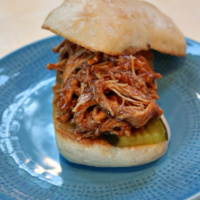 slow cooker pulled barbecue chicken sandwich on a blue plate