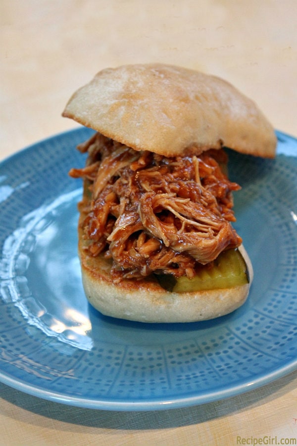 Slow Cooker Pulled Barbecued Chicken Sandwiches recipe from RecipeGirl.com #slow #cooker #slowcooker #crockpot #pulled #bbq #barbecue #barbecued #chicken #sandwiches #recipe #RecipeGirl Slow Cooker Pulled Barbecued Chicken Sandwich on a blue plate
