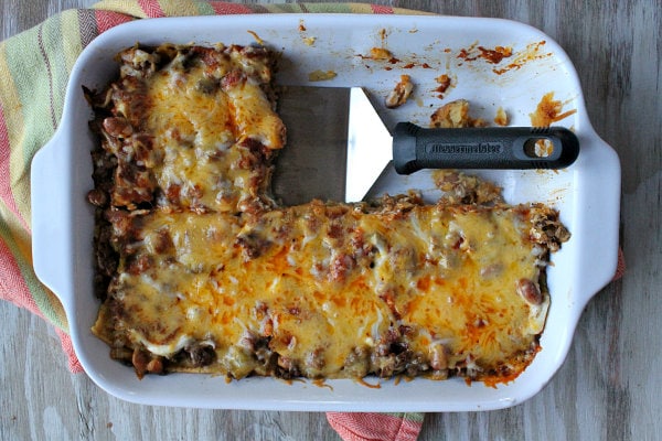 Beef and Bean Enchilada Casserole recipe from RecipeGirl.com #beef #bean #enchilada #casserole #recipe #recipegirl #easy #weeknight #dinner Beef and Bean Enchilada Casserole in a white baking dish