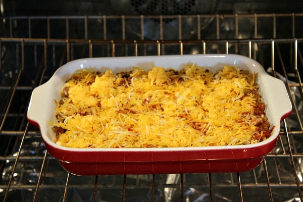 Beef and Bean Enchilada Casserole recipe from RecipeGirl.com #beef #bean #enchilada #casserole #recipe #recipegirl #easy #weeknight #dinner Adding cheese to Beef and Bean Enchilada Casserole