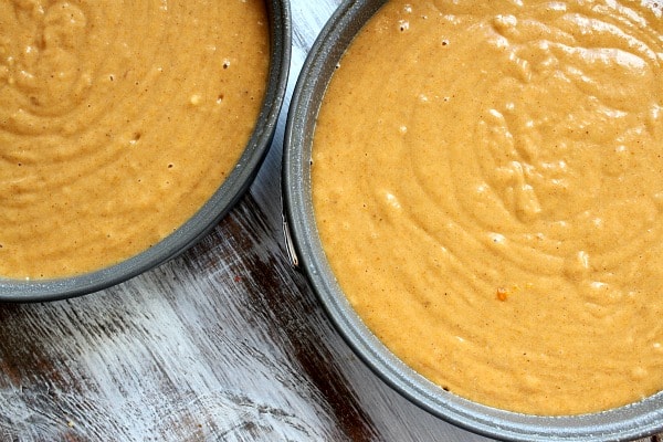 Two round cake pans with pumpkin cake batter