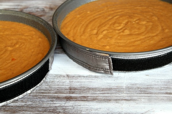 two round cake pans with pumpkin cake batter
