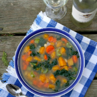 butternut squash and kale soup in a blue bowl