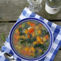 bowl of butternut squash and kale soup in a white bowl