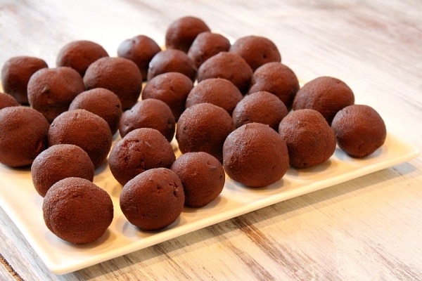 chocolate chocolate chip cookie dough shaped into round truffles on a white plate