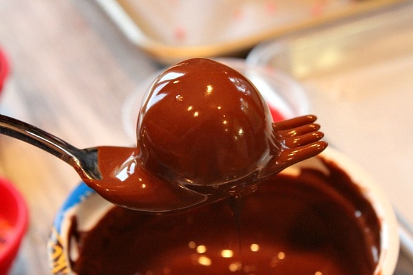 chocolate chocolate chip cookie dough dipped in chocolate with a fork