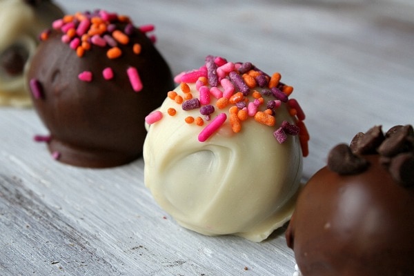 Chocolate Chocolate Chip Cookie Dough Truffles- 3 in a row two chocolate dipped and one white chocolate dipped with sprinkles on top