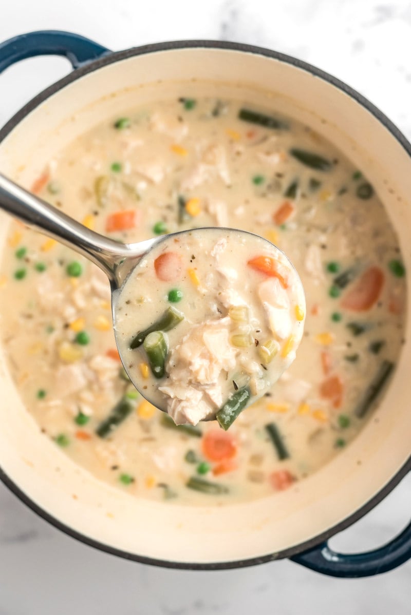 creamy chicken and rice soup in a pot with a ladle