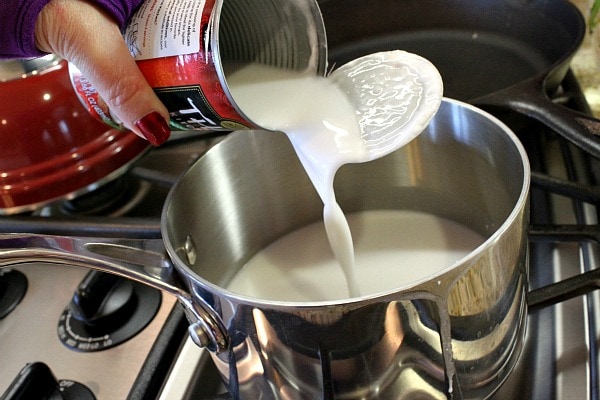 pouring coconut milk into pan