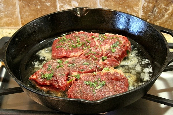 Pan Fried Lemon- Garlic Rib-Eye Steaks in a frying pan