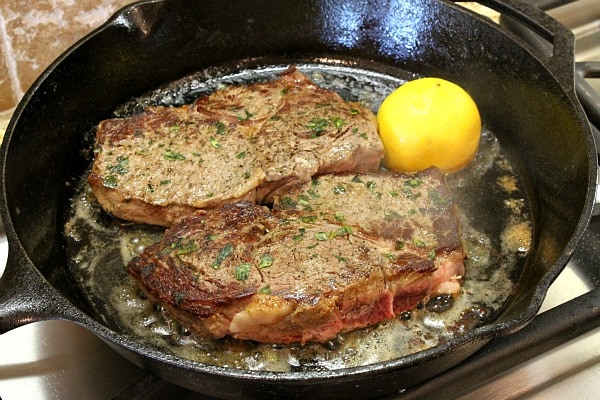 Pan Fried Lemon-Garlic Rib-Eye Steaks from RecipeGirl.com #ribeye #steaks #leman #recipegirl Pan Fried Lemon- Garlic Rib-Eye Steaks in a frying pan