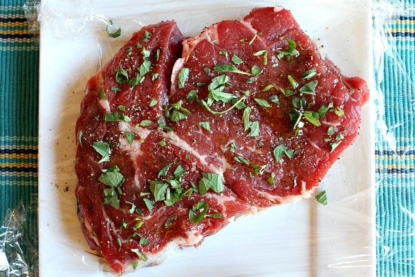 Pan Fried Lemon- Garlic Ribe-Eye Steaks raw on a plate