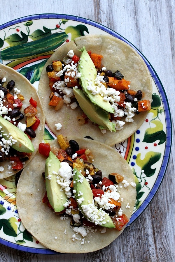 Roasted Vegetable and Black Bean Tacos from RecipeGirl.com #roastedvegetables #tacos #blackbeantacos #vegetarian #RecipeGirl three finished Roasted Vegetable and Black Bean Tacos on a colorful plate