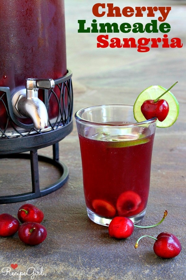 Cherry Limeade Sangria in a glass with container of sangria beside it