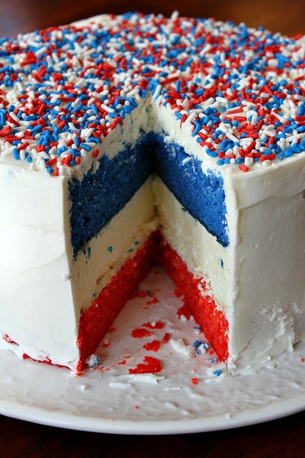 red, white and blue cheesecake cake sliced into to see the inside- displayed on a white plate