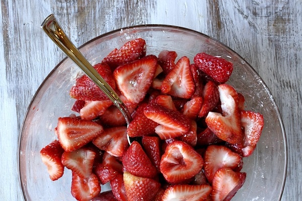 Chopped strawberries in glass bowl with spoon