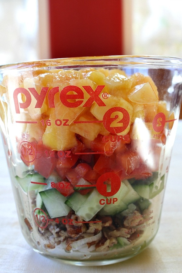 Ingredients for Peach and Pecan Quinoa Salad in a measuring cup