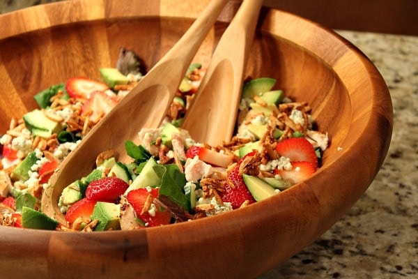 strawberry chicken salad in a big wooden bowl with wooden serving spoons