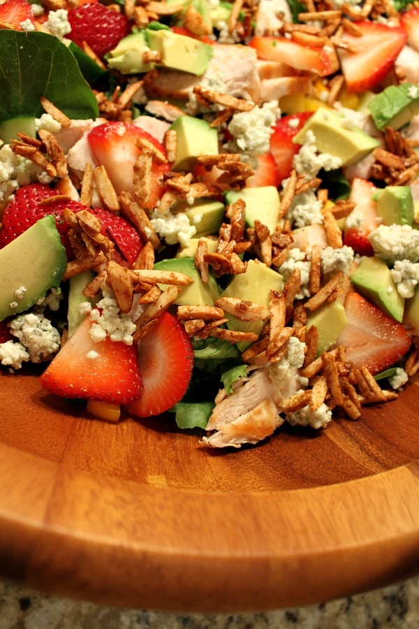 Strawberry Chicken Salad with Bacon and Avocado recipe from RecipeGirl.com #strawberry #chicken #salad #recipe #bacon #avocado #RecipeGirl close up of strawberry chicken salad in a big wooden bowl