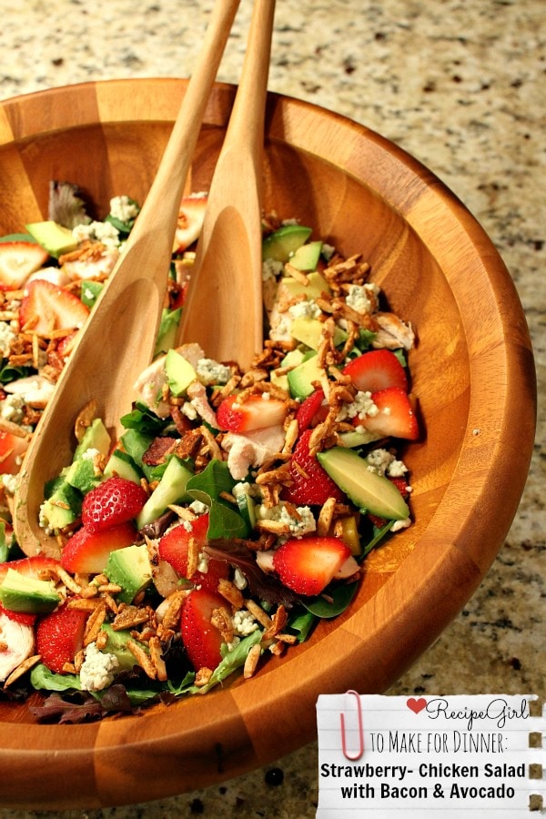 strawberry chicken salad in a big wooden bowl with wooden serving spoons