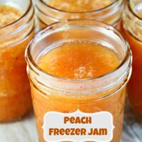 peach freezer jam with a label and several more jars of peach jam in the background.