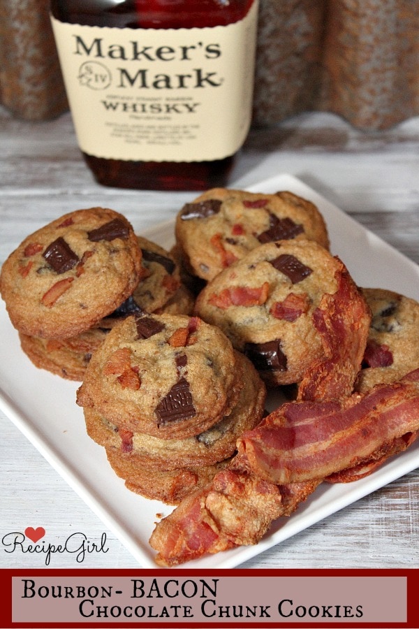 Bourbon Bacon Chocolate Chunk Cookies sitting on a white plate with some bacon slices. Maker's Mark Whisky in the background