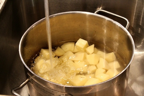 Perfect Mashed Potatoes recipe from RecipeGirl.com #perfect #mashed #potatoes #recipe #RecipeGirl Adding water to potatoes in large pot