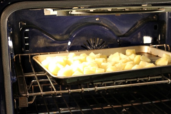 Perfect Mashed Potatoes recipe from RecipeGirl.com #perfect #mashed #potatoes #recipe #RecipeGirl potatoes on a baking sheet in the oven