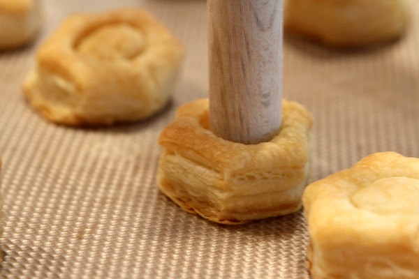 Pushing baked puff pastry cups with wooden dowel