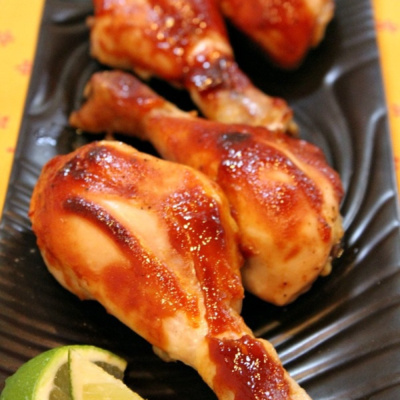 Hoisin Chicken Drumsticks with lime on brown platter