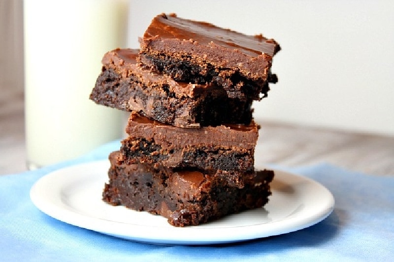 stack of four brownies on a white plate