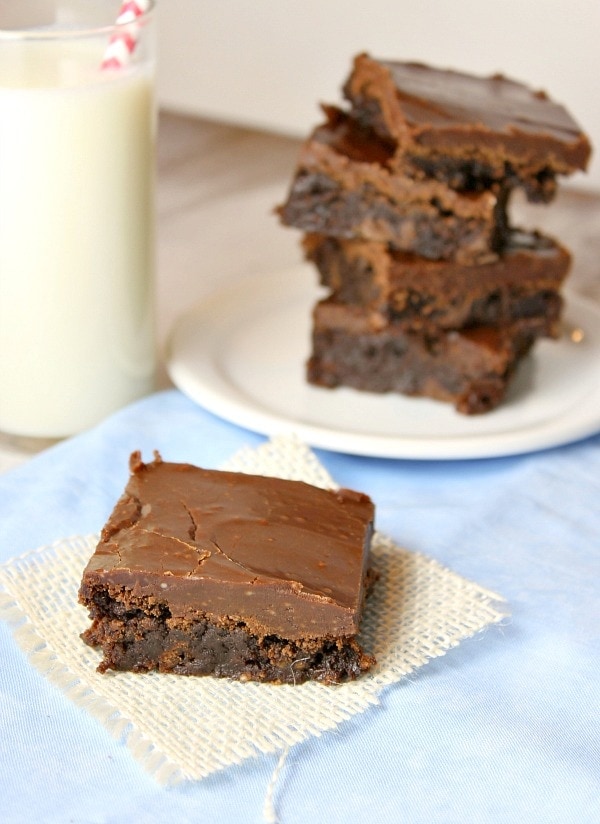 fudgy frosted brownie with stack in background