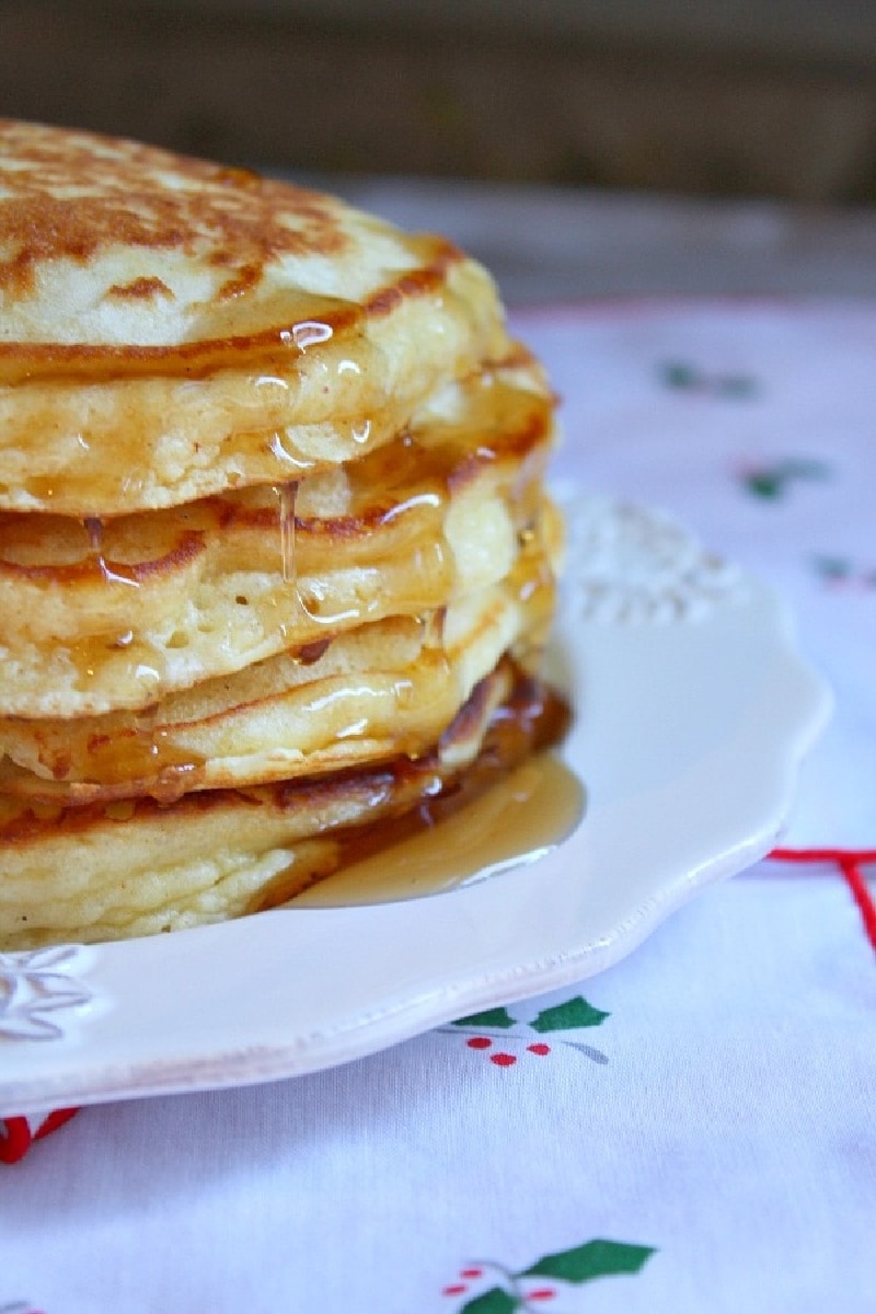 eggnog pancakes in a stack with syrup