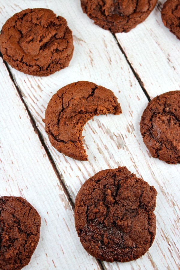 Cocoa Fudge Cookies on a board one with bite taken out