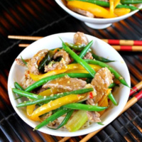 szechuan orange ginger beef in two bowls with chopsticks