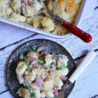 serving of ham and cheese gnocchi on plate with casserole dish too