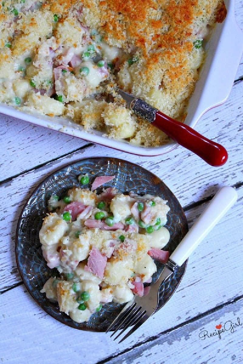 serving of ham and cheese gnocchi on plate with casserole dish too