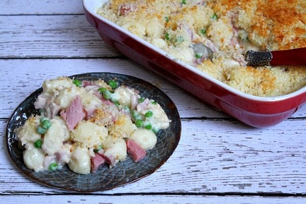 Ham and Cheese Baked Gnocchi recipe from RecipeGirl.com #ham #cheese #gnocchi #recipe #RecipeGirl Ham and Swiss Baked Gnocchi on a serving plate with casserole dish in background
