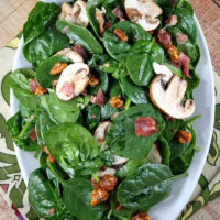 spinach salad on a white platter