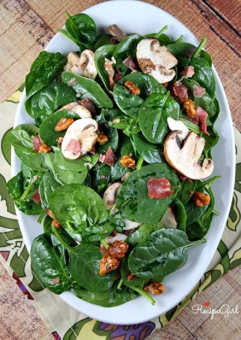 Spinach Salad with Hot Prosciutto Dressing recipe from RecipeGirl.com #spinach #salad #hot #prosciutto #dressing #recipe #RecipeGirl spinach salad on a white platter