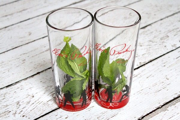 Two glasses with fresh mint sitting on a white wood plank board background